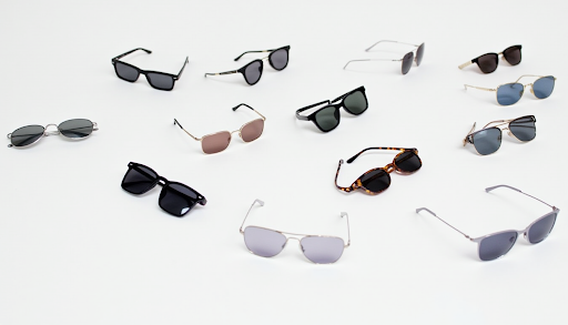 A diverse collection of trendy sunglasses displayed on a white background, featuring aviator, square, wire-frame, and tortoise shell styles.